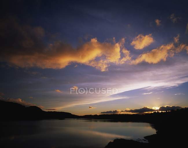 Захід сонця над озерною водою — стокове фото
