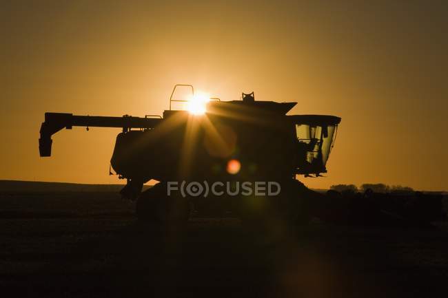 Silhouette des Mähdreschers mit Sonnenbrand — Stockfoto