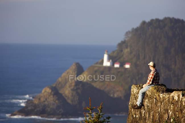 Uomo seduto sulla scogliera — Foto stock