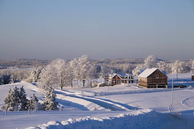 Celeiro e casas sobre a neve — Fotografia de Stock
