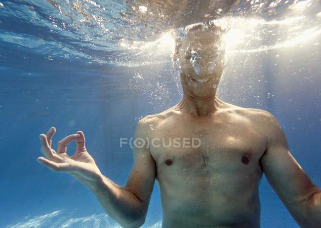 El hombre haciendo mediación posan bajo el agua - foto de stock