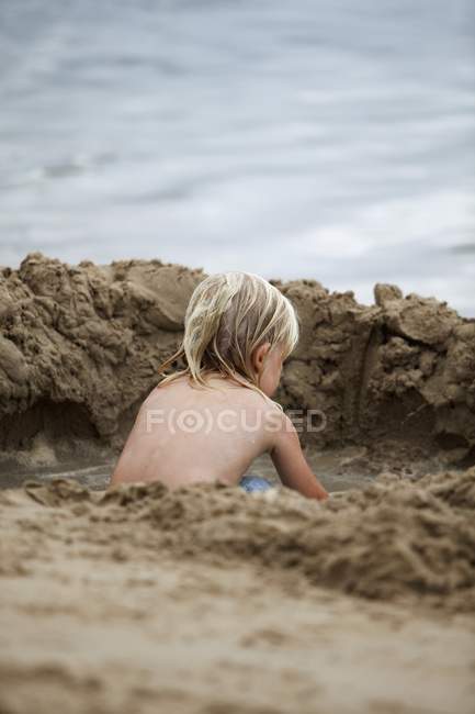 Un ragazzo gioca nella sabbia vicino all'acqua; Currumbin, Gold Coast, Queensland, Australia — Foto stock