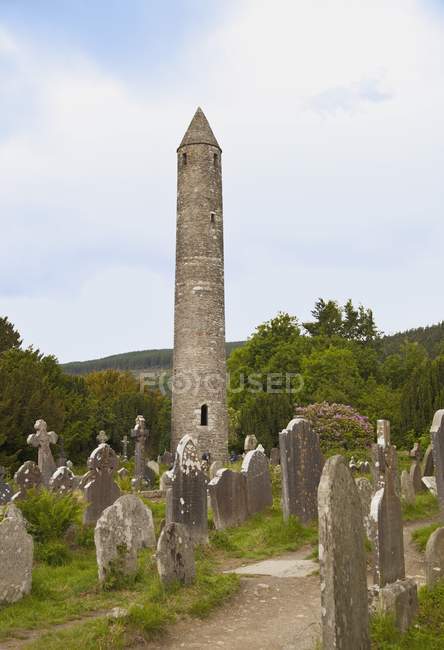 Pietre tombali nel cimitero e torre — Foto stock