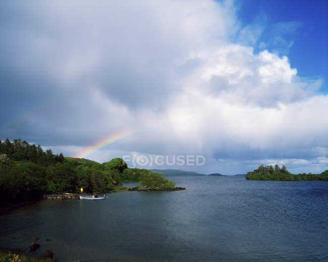 Lake with rainbow above — стоковое фото