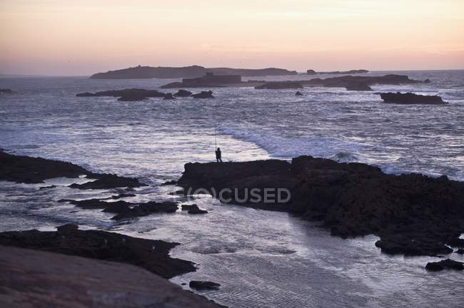Pescatore solitario al tramonto — Foto stock