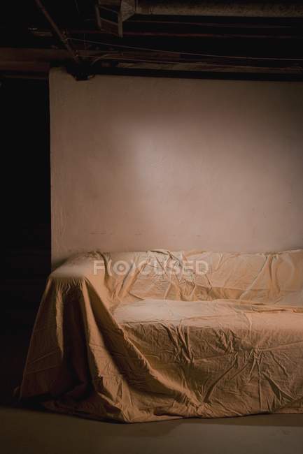 Canapé abandonné recouvert de drap de lit, espace de copie — Photo de stock