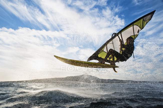 Atleta femenina extrema adulta en tabla de windsurf. Tarifa, Cádiz, Andalucía, España - foto de stock