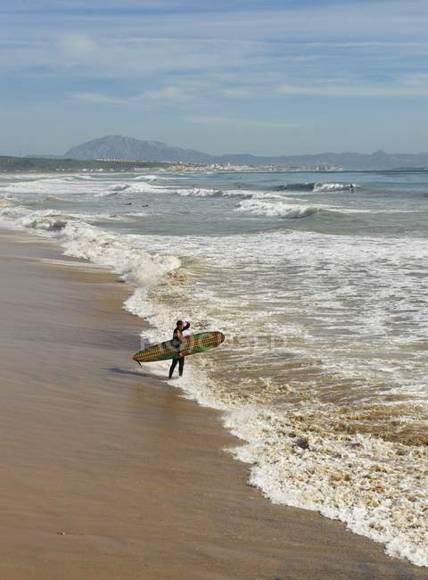Tarifa, costa de la luz, cadiz, andalucia, spanien; ein surfer am hurrikan hotel beach — Stockfoto