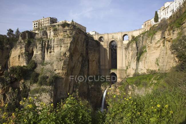 Puente con una cascada y acantilados de roca - foto de stock