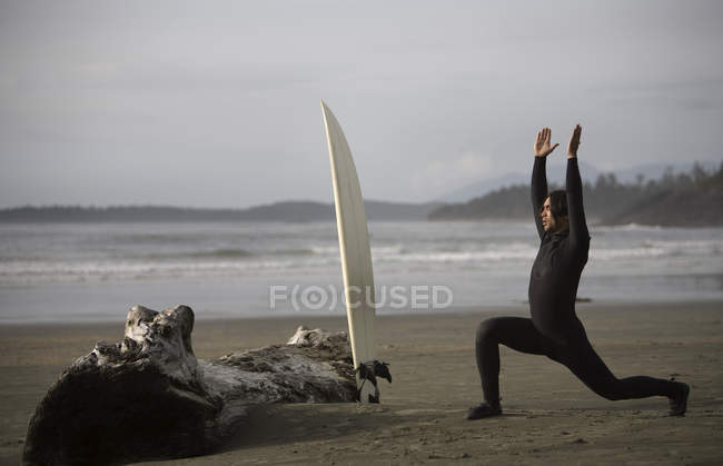 Surfista che si estende sulla spiaggia — Foto stock