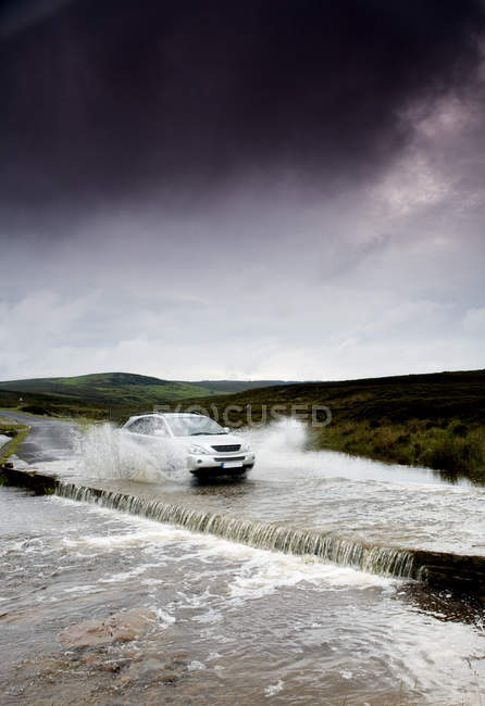 Auto fährt überflutete Straße hinunter, yorkshire, england — Stockfoto