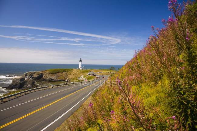 Lighthouse on shore and road — Stock Photo