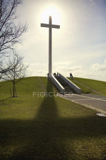 Croix contre soleil sur colline — Photo de stock