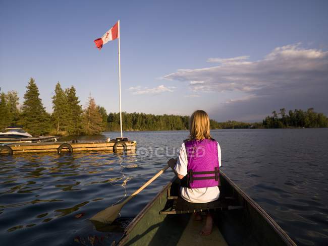 Задній вид жінка каное в озеро — стокове фото