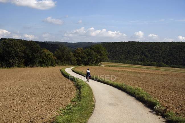 Ciclista femenina en camino de tierra - foto de stock