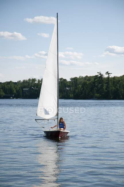 Junge Frau schwimmt im Segelboot, See des Waldes, Ontario, Kanada — Stockfoto