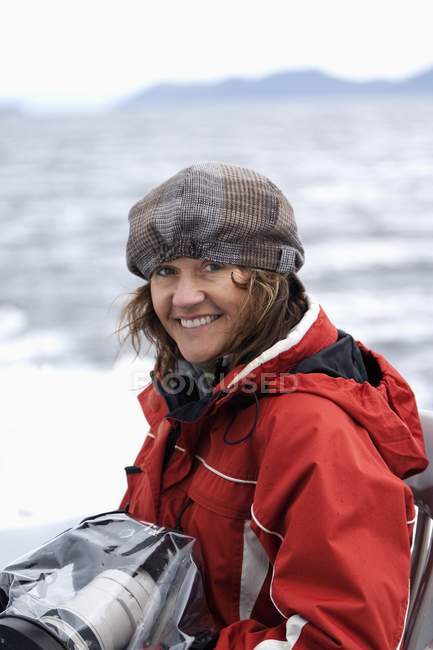 Woman holding camera wrapped in plastic on cruise ship tour in Alaska, USA — Stock Photo