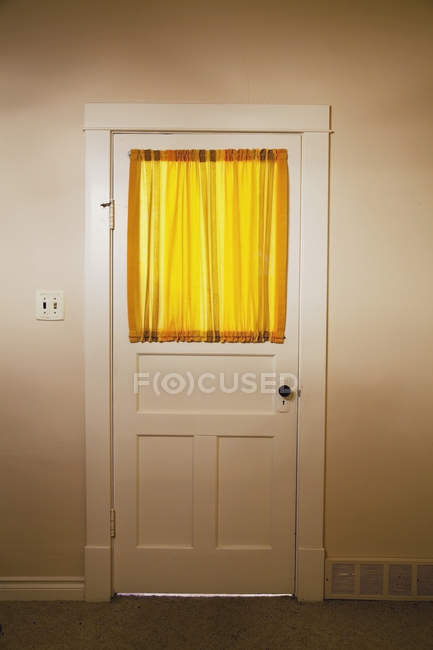 Interior door of farmhouse with yellow curtains on window — Stock Photo