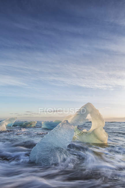 Iceberg sulla spiaggia con onde — Foto stock