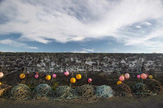 Bunte Bojen und Seile hängen entlang der Steinmauer. Dumfries und Galloway, Schottland — Stockfoto