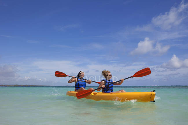 Zwei Frauen in Rettungswesten paddeln in einem gelben Boot; punta cana, la altagracia, Dominikanische Republik — Stockfoto