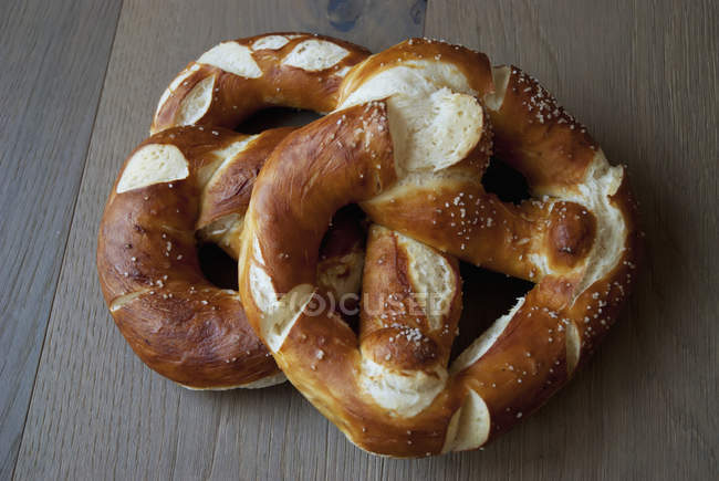 Dos sabrosos pretzels sobre mesa de madera - foto de stock