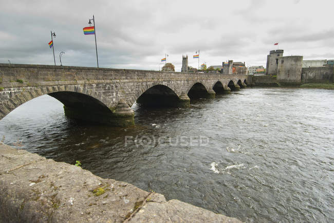 Flags over a river with a castle — Stock Photo