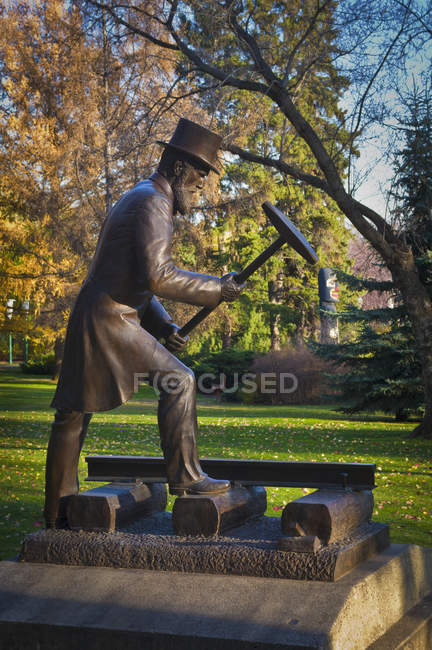 Bronze statue of railroad official hammering — Stock Photo