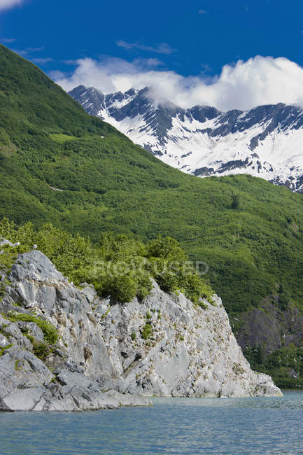 Rocky cliff against water — Stock Photo