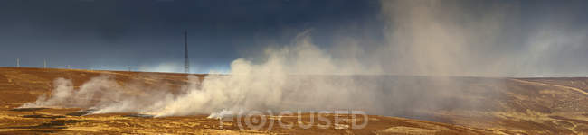 Smoke billowing up from landscape — Stock Photo