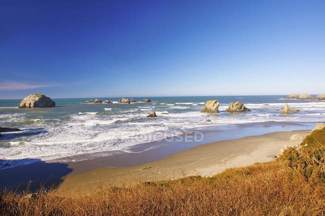 Rock formations at low tide on bandon beach — Stock Photo