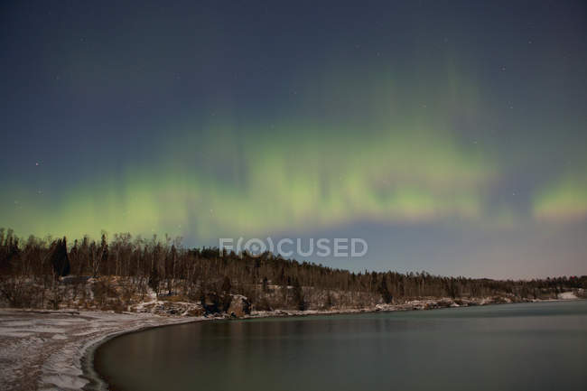 Северное сияние Aurora Borealis Over Lake — стоковое фото