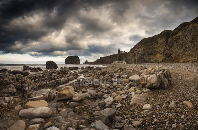 Praia rochosa ao longo da borda águas — Fotografia de Stock