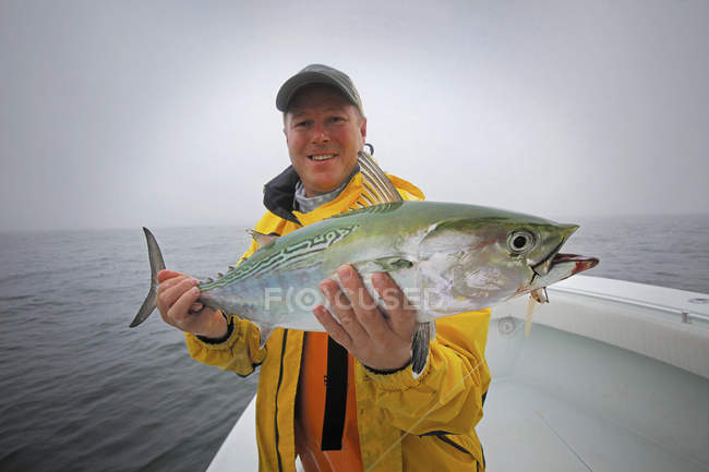 Homme détenant des captures fraîches de faux thon germon sur le bateau — Photo de stock