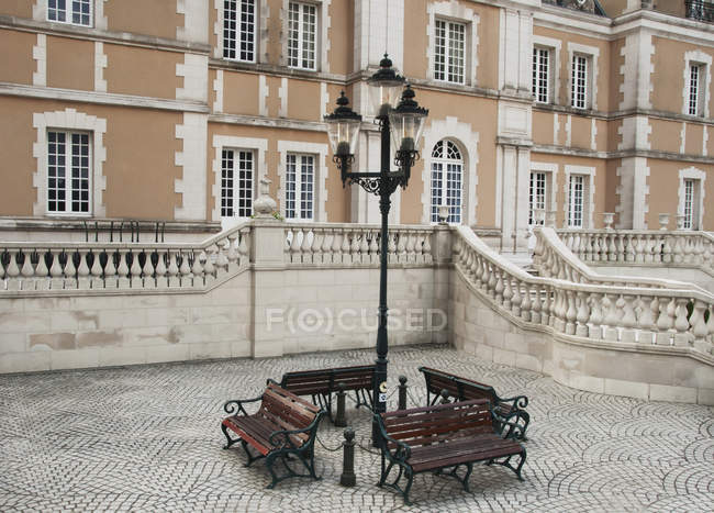 Скамейки вокруг столба лампы — стоковое фото