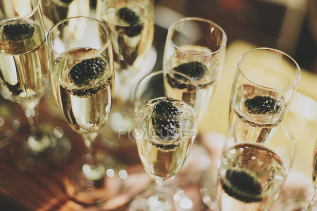 Copas de champán en filas con efecto borroso - foto de stock