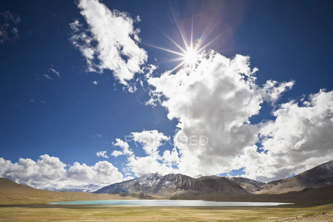 Luz solar e nuvens sobre o lago e montanhas — Fotografia de Stock