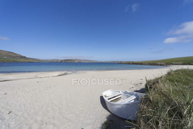 Una barca abbandonata su una spiaggia — Foto stock