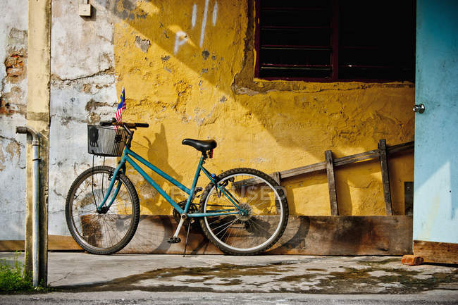 Bicicleta estacionada contra la pared - foto de stock