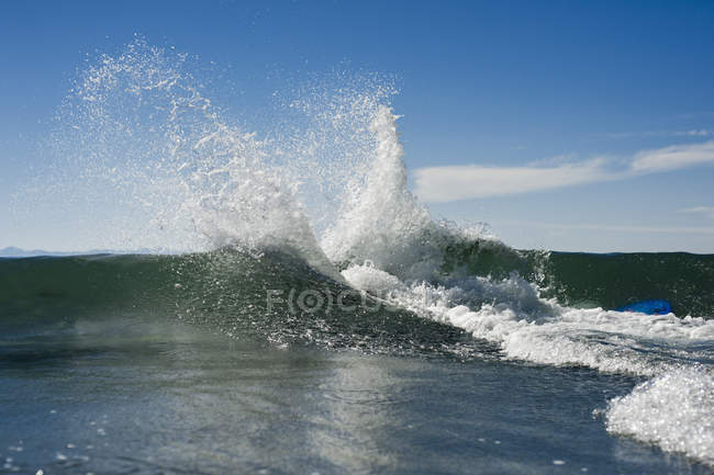 Salpicar agua en la parte superior de la ola - foto de stock
