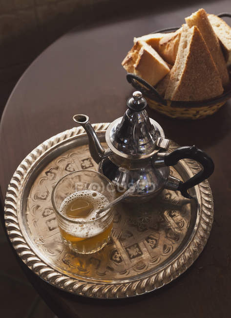Tetera de té de menta y pan árabe en la superficie oscura - foto de stock