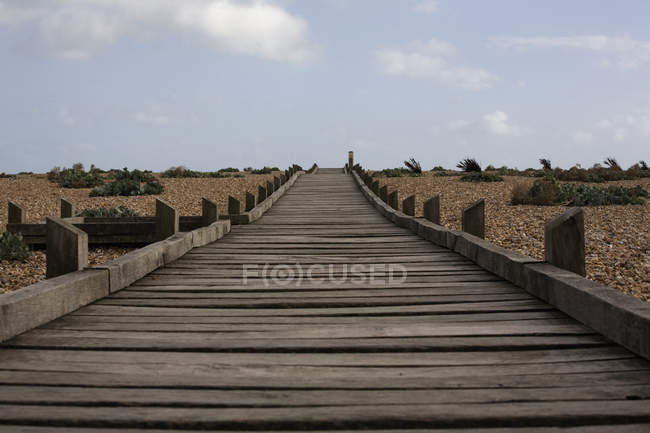 Boardwalk de madeira através do cascalho — Fotografia de Stock