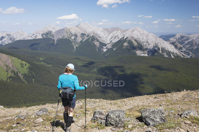Escursionista femminile con pali escursionistici — Foto stock