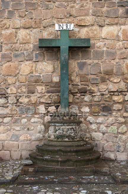 Cruz verde contra muro de piedra - foto de stock