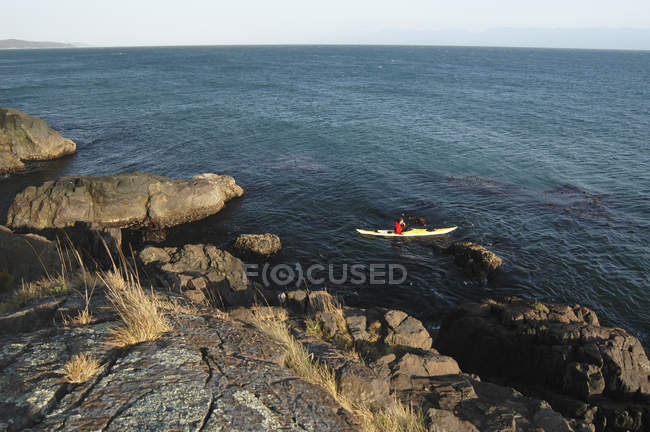 Hombre Kayak Off Shoreline - foto de stock