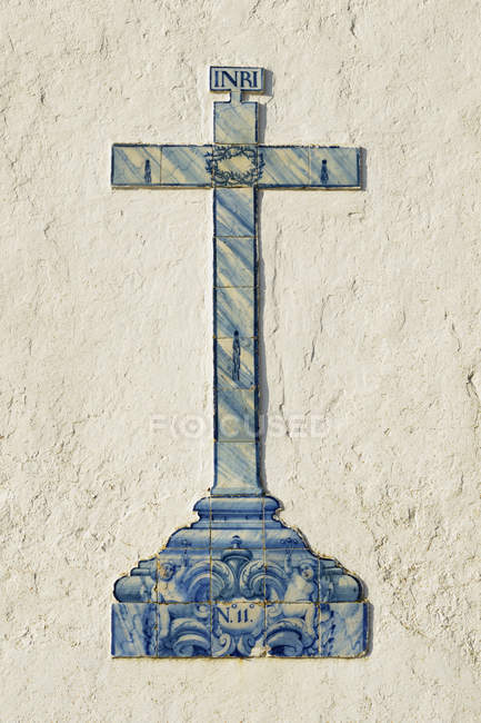 Голубой крест на белой стене — стоковое фото