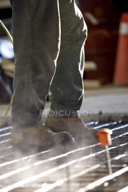 Рабочий, идущий по бетону — стоковое фото