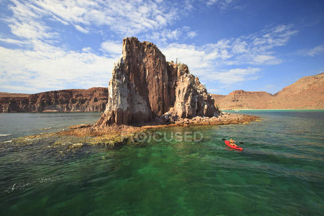 Touristin paddelt im roten Boot auf See — Stockfoto
