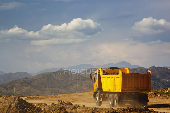 Camion à benne basculante chargé avec conduite de la terre — Photo de stock