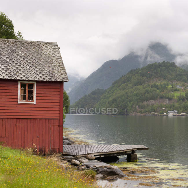 Bâtiment rouge et quai le long du Hardangerfjord — Photo de stock